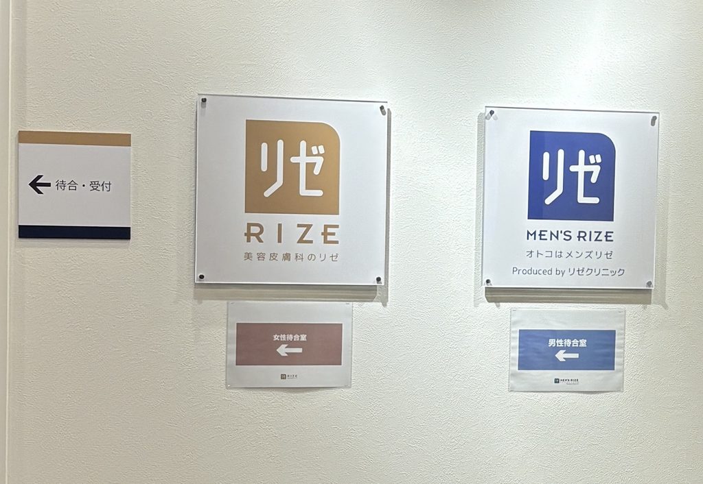 リゼクリニック銀座院の入り口にある看板。リゼとメンズリゼの看板が並び、女性待合室と男性待合室の案内がある。